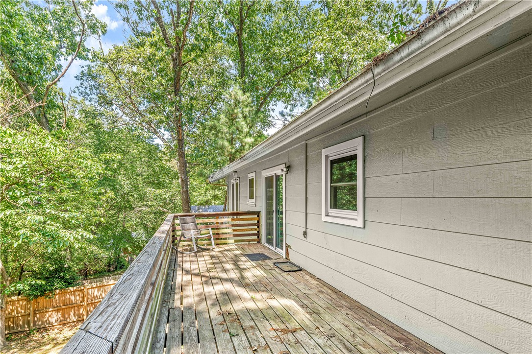 A spacious four-bedroom, three-bath home nestled in the trees, offering peace and privacy. Enjoy an expansive deck with a delightful view of Kingswood Golf Course. The main level features an open floor plan that includes a cozy living room with a stone fireplace, a large kitchen, and a comfortable primary suite. The lower level offers a generous family room with another stone fireplace, a fourth bedroom, and a full bath perfect for guests or multi-generational living. Enjoy the beautiful natural surroundings and easy access to nearby lakes.