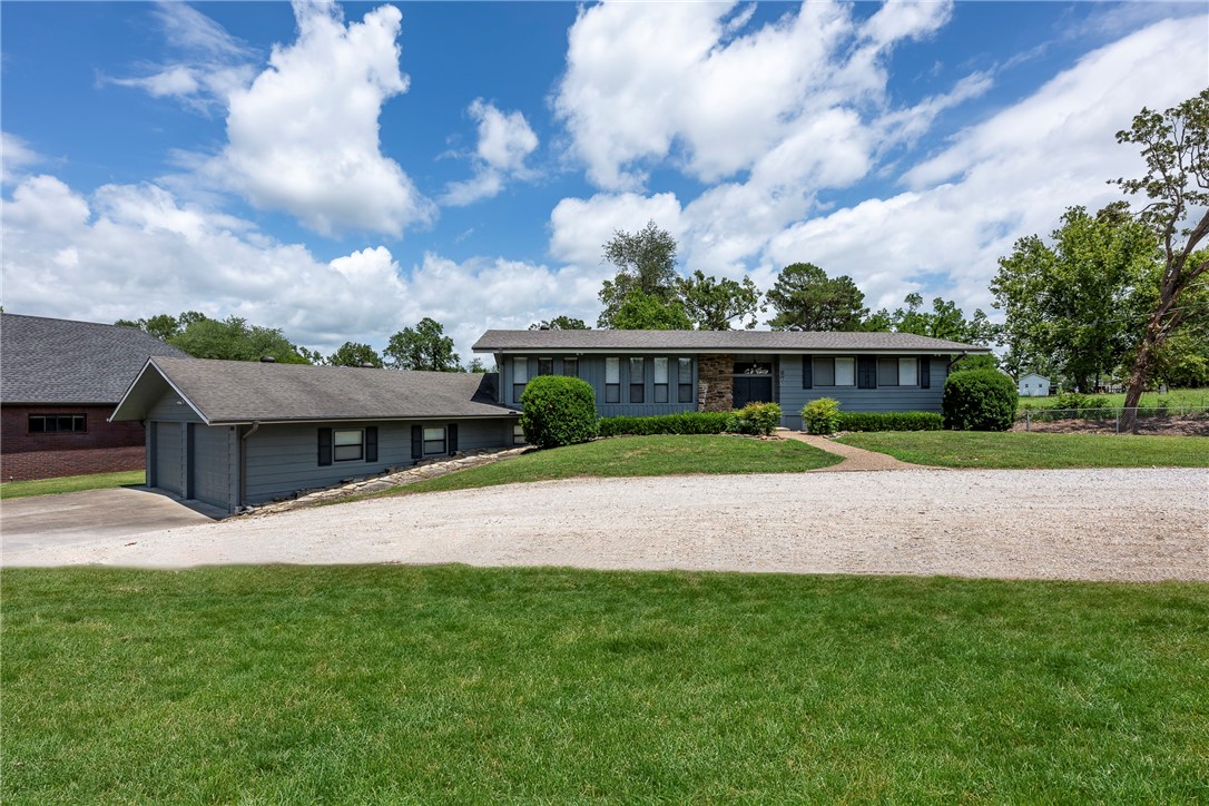 Prairie Style home on huge lot (.83) in Downtown Bentonville. This home has character and style! Unique flagstone floors, vaulted ceilings with tongue in groove wood & native stone fireplaces. This is one of the only Mid-Century Modern style homes in town! Walk to neaby schools or hop on the bike path right out the front door. A huge shop & garage can park 4 cars and still have storage space!  Please provide ample notice for appointments- this is an active Airbnb.