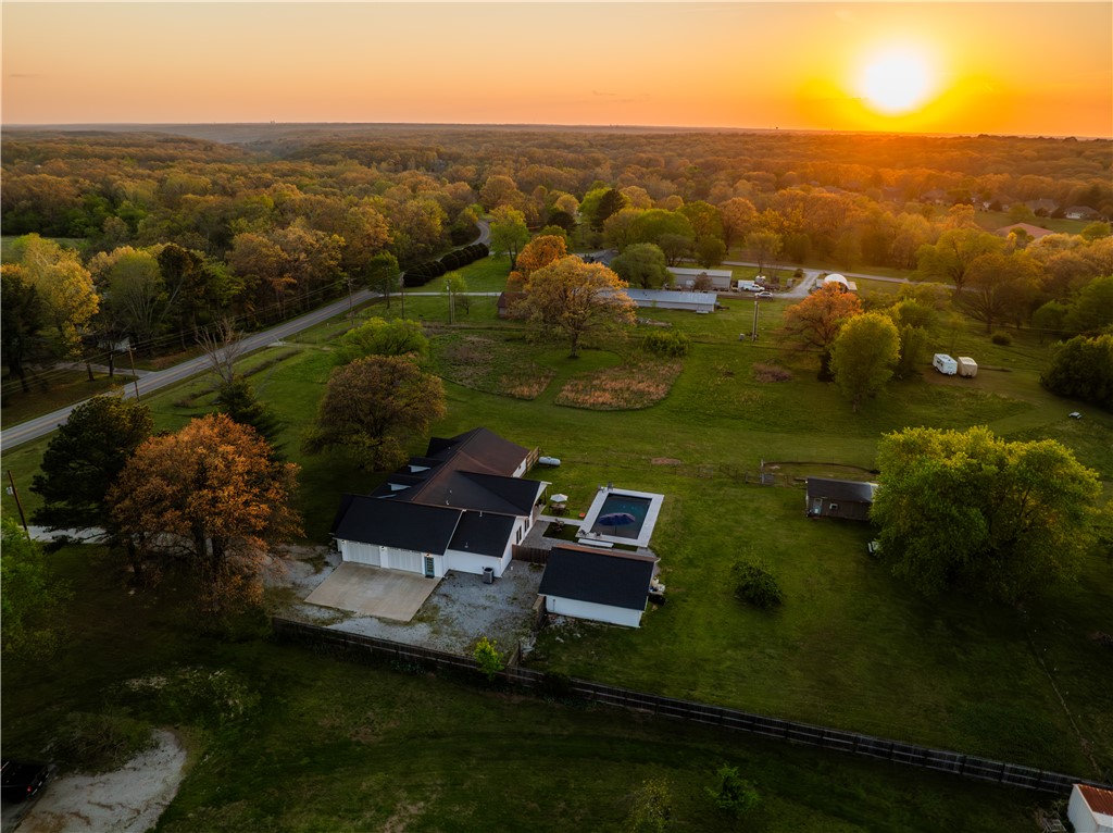 Welcome to The Bentonville Trailside Homestead, a beautifully curated modern farmhouse where wide-open country living meets city convenience. Located 15 minutes to the Bentonville Square, easy access to I-49, and only .5 miles to the Snowbird Trailhead and Back 40 Trail System, this property truly has it all. Set on acreage with sweeping Ozark skies, this home features spacious living areas, a fully equipped kitchen, and a game room perfect for gatherings. A large attached garage and a detached garage offer exceptional storage and workspace, while a cooled shed adds a versatile bonus space for hobbies. Outside, enjoy a private pool, expansive patio, fire pit, and sunset views. Mountain biking, country hobby living, and city convenience all in one. This is the lifestyle property families dream about. Offered fully furnished and operating as a successful short-term rental, it's also a turnkey investment opportunity. Please note: the home has been remodeled to have 4 bedrooms, but there is a 2 bedroom septic system.