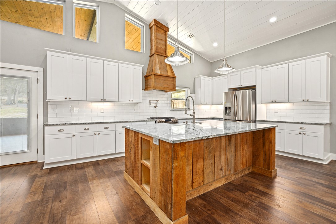 Unique, spacious and potentially income producing property with unbeatable craftsmanship near Taylor Park, the Razorback Greenway bike trail and Drake Field Airport. This remarkable property includes three separate homes in one package deal. The beautiful 3,500+ sq. ft main home has three bedrooms, 2 1/2 bathrooms with open concept living, kitchen and dining area. The newly renovated barn home has an upstairs loft with a master bed and bath and downstairs living and kitchen. Preserving some of its original rock and architecture, the cottage home is wonderfully crafted to include a modern kitchen, living and bedroom. Imagine using the barn home and cottage as income producing properties, starter homes for your adult children, or mother-in-law apartments. Sitting on 4.2 acres of land that includes three sites for future homes, an RV pad with hookup for sewage, water and electricity, an 18x28 barn, garden, creek and pond.