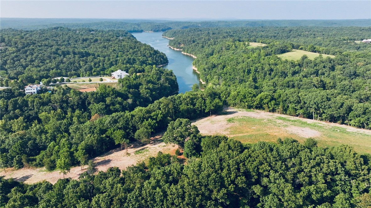 Discover the freedom to create your own Beaver Lake retreat on this beautiful 22-acre property in the gated Lakeshore Farms at Nelson Hollow community. A scenic hilltop homesite has already been cleared, offering the perfect place to build your dream home with beautiful lake views. Electric is already on site, making your vision one step closer to reality. Explore the established trails by ATV or side-by-side, enjoy the privacy of mature trees, or take a short walk to the lake for fishing, kayaking, or simply soaking in the peaceful surroundings. With no required build timeline, you can purchase now and build when the time is right. Whether you're looking for a full-time residence, weekend getaway, or recreational escape, this property offers the rare combination of adventure, privacy, and breathtaking natural beauty.