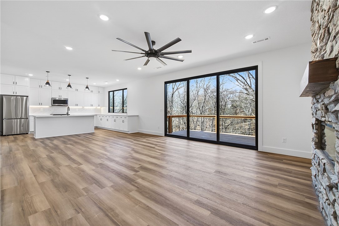 Look no further, this beautiful new construction home is perfectly situated in the heart of Bella Vista! Located in the Bentonville School District and just 15 minutes from the new Walmart Home Office, this home backs up directly to the Tunnel Vision Bike Trail, offering unmatched access to Bella Vista's renowned trail system right from your backyard. Inside, you'll find 10-foot ceilings, custom cabinetry, granite countertops, large windows, luxury vinyl plank flooring, and stylish modern finishes throughout. The open split floor plan is designed for functional everyday living, featuring a spacious primary suite and walk-in closets. The outdoor deck overlooks a wooded setting, ideal for nature lovers and those seeking privacy all while being close to daily conveniences.