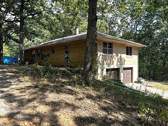This fixer-upper offers an opportunity for your ideal retreat on 4 peaceful acres with easy access to Winslow and Northwest Arkansas. The property includes a mix of open and wooded land, with approx. 3 wooded acres featuring native plants. It is also set up for a chicken coop and attracts abundant wildlife. The home features 1,624 sq. ft. on the main level plus a basement with potential to be finished for living space, including plumbing for a bathroom and shower. The interior is filled with natural light, creating an inviting atmosphere, with beautiful views throughout. 
Several updates have already been completed, a new roof in 2021, new garage doors in 2019, a new septic system in 2016, and updated chimney and wood heat flues in 2019 supporting two wood stoves. One installed and functioning downstairs with the flue ready to set up a stove upstairs in the main living area.  It does need updates such as foundation sealing and stabilization, new flooring, doors, and paint.