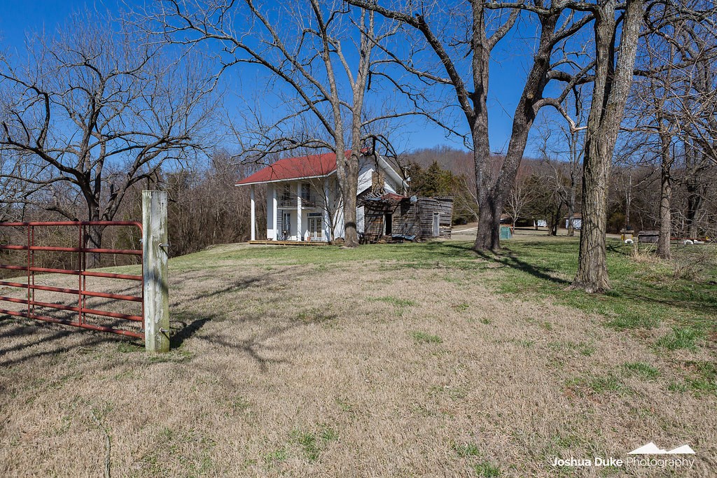 Beautiful acreage with development opportunity or build your dream home.  The 31+ acres is aprox. 16 acres of pasture, 15 acres of wooded land, and is situated in a way that feels very private.  2 homes, offering workshop and storage areas, hen house, large pole barn, storm shelter, rural water, plus two wells.