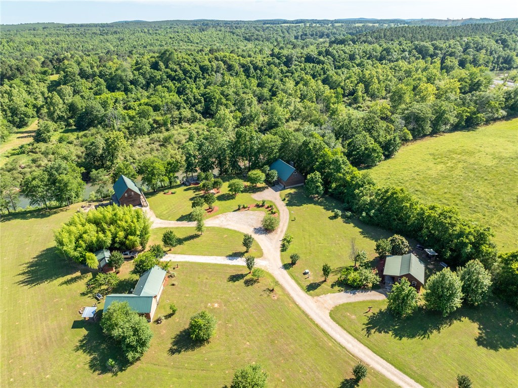 This rare, income-producing riverfront property includes five fully furnished cabins situated along the Caddo River. Currently operated as a successful short-term rental business, the property offers immediate income potential and room for future development. Grounds feature mature trees, fruit trees, fire pits, grills, and a scenic deck with picnic tables overlooking the river. Cabin Details: River Ridge– 2,400± SF | 3 BR, 2 BA | Sleeps 8 Sits directly on the river with stunning views and generous living space Dreamcatcher– 1,700± SF | 3 BR 2 BA | Sleeps 8 Also perched along the riverbank, this retreat offers great views and a charming layout Sundancer– 850± SF | 2 BR, 1 BA | Sleeps 6 Centrally located on the property—perfect for smaller groups or couples Morning Star – 600± SF | 2 BR, 1 BA | Sleeps 6 Compact and welcoming, this cabin is a favorite among return guests Star Gazer– 2,500± SF | 3 BR, 2 BA | Sleeps 8 The newest and largest cabin, Features an incredible covered patio with an outdoor fireplace .
