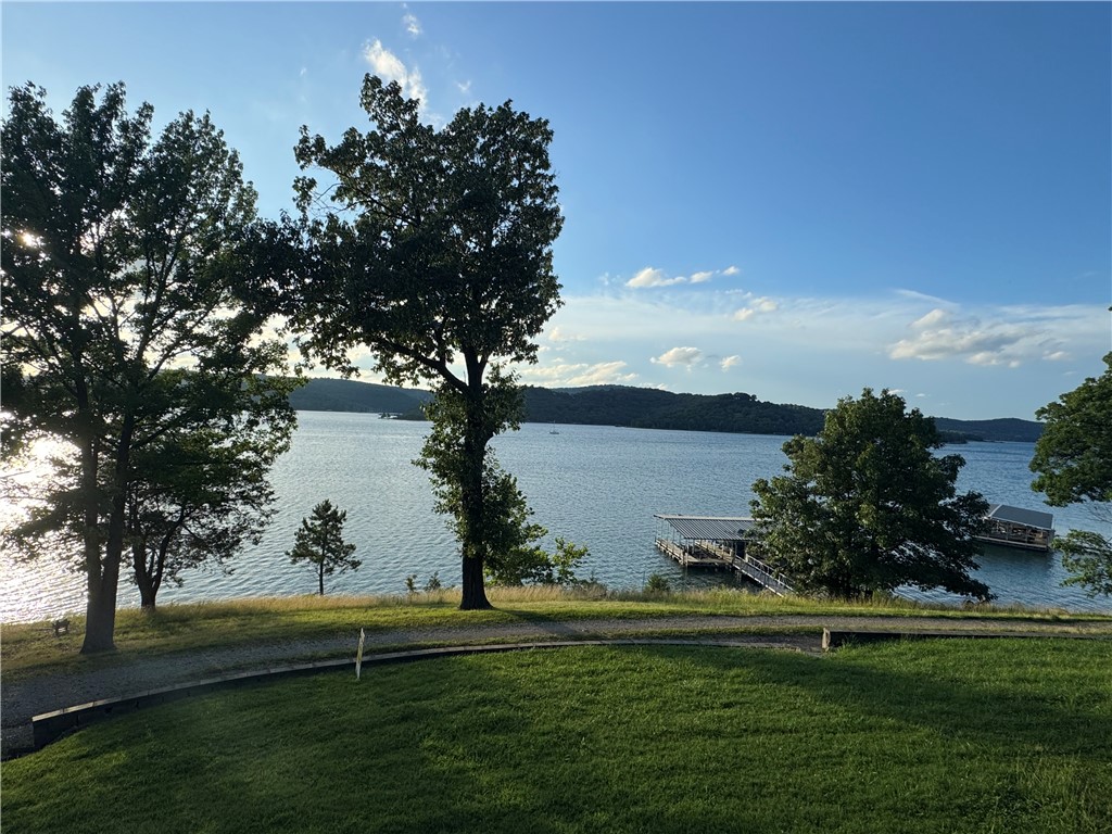 Enjoy the beauty of lakefront living on Beaver Lake in this charming 2-bedroom, 1-bath retreat with breathtaking water views and (2) boat slips. The interior showcases cathedral wood ceilings that enhance the home’s natural charm and open feel. Step outside to the covered deck and take in panoramic lake views year-round. Included are (2) 8' x 20' boat slips in a community dock a short walk from the house, along with an unfinished 288 sq ft basement storage room for added convenience. Most furniture and appliances are included, making this home truly move-in or rental ready. Perfect as a primary residence, weekend escape, or income-producing property, this home captures the essence of lakeside living.