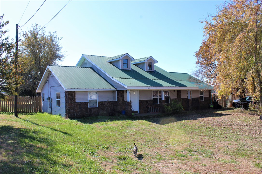 Wow! Here is your chance to own 1.00 flat acre, more or less, plus a nearly 2,300 sqft (per courthouse) home only 2 miles from Cardinal Stadium. Located in a country setting in lovely Farmington, this 4 bedroom, 2 bath home doesn't have an inch of carpet. The large kitchen features ample counterspace and metal tile backsplash. Large rooms including the finished garage are highlighted with tons of storage space. The metal roof and updated vinyl, double paned windows accompany the newer HVAC system as unneeded upgrades. Living Room and staircase have stylish and  versatile laminate flooring.  The fenced lot is surrounded by farmland and quite serene. The plentiful road frontage allows a potential property split or room to build your dream shop.