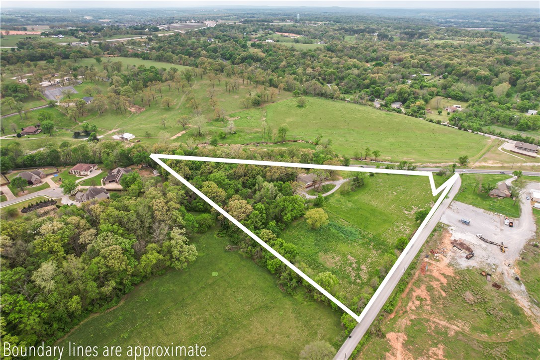 At the heart of it all! Minutes from XNA Airport, I-49, Hebron & Shaw Parks, and Walmart Arkansas Music Pavilion (The AMP). Located across from a major planned development. Buyer to verify zoning, planning, and development potential with the City of Springdale and Benton County. Value is in the land. Highway 112 is planned for expansion into a divided four-lane highway from Springdale to Bentonville, with the Highway 612 bypass currently expanding from Hwy 112. Close to parks, trails, and recreation supporting Northwest Arkansas’ quality of life. Existing home included, as is. Showings by appointment only with verified financials. Proof of funds or lender pre-approval required. County records states 7.88 acres although a current survey indicates 7.08 acres. Arkansas Highway 112 is currently undergoing a widening project. As a result, the exact land measurements may vary between county records and the most recent surveys.
