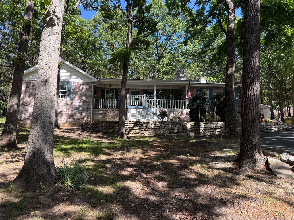 Home backs up to Saunders Heights (City Owned) the outside offers a park like setting with beautifully done landscaping that uses natural stone and enhances the natural wooded back property and shows off the rolling green field in the front of the property. Brick home with inviting "Southern" Porch with plenty of room to sit and enjoy the view. Inside has beautiful hardwood floors and the living room has wood burning fireplace with custom built ins flanking each side one housing a place to load wood from the garage. Kitchen boasts wonderful features like slide out trash can drawers and pantry drawers, beautiful granite counter tops and stone looking tile backsplash all appliances stay with the home. Dining area has custom plate shelves and shiplap walls painted in a very on trend pastel. Both front door and back door have a unique retractable screen doors perfect for letting fresh air in. Laundry/Mudroom houses washer and dryer, soaking sink and cabinetry. 3 bed 2 bath, storm shelter, and so much more.