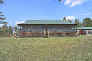 This rustic cabin style home is warn and inviting to any one who wants a rustic life away from the hustle and bustle of people.  Inside it has 3 bedrooms and an office or a 4th guest room, two full baths, a huge kitchen with a pantry you'll love and tons of cabinets.  The living room is huge with a large wood fireplace as the focal point.  Outside there is a screened in front porch that runs the length of the house.  There is a 30x50 shop set up for a guy who likes to tinker, a garden spot and a little over 20 wooded acres loaded with deer.  If this sound like your idea of a good life you should take a look.