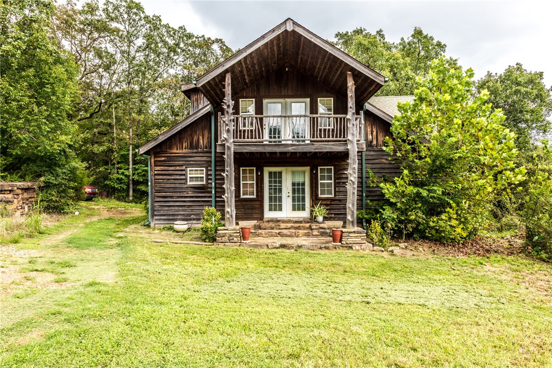 Beautiful Views! Sitting on 5.00 acres MOL, this 3DB/2BA cabin like home features cedar exterior, wood floors throughout Living Room, gorgeous abundant cabinetry in kitchen, tiled counter tops, SS appliances, spacious bedrooms, second living area upstairs and covered balcony overlooking the your gorgeous acreage & views!