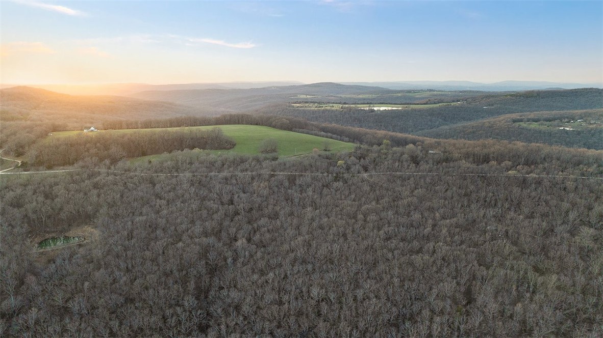 Have your own gorgeous piece of Northwest Arkansas paradise! This 21.21 acres is every outdoorsman's dream... whether you enjoy hunting, ATVs, hiking, or camping - this land will deliver! The wet weather creek keeps the bears and deer coming. Beautiful rocks and hills make this property a great place to play! Outbuilding and camper included. Need more land? Adjacent 22 acres also for sale! MLS 1304357