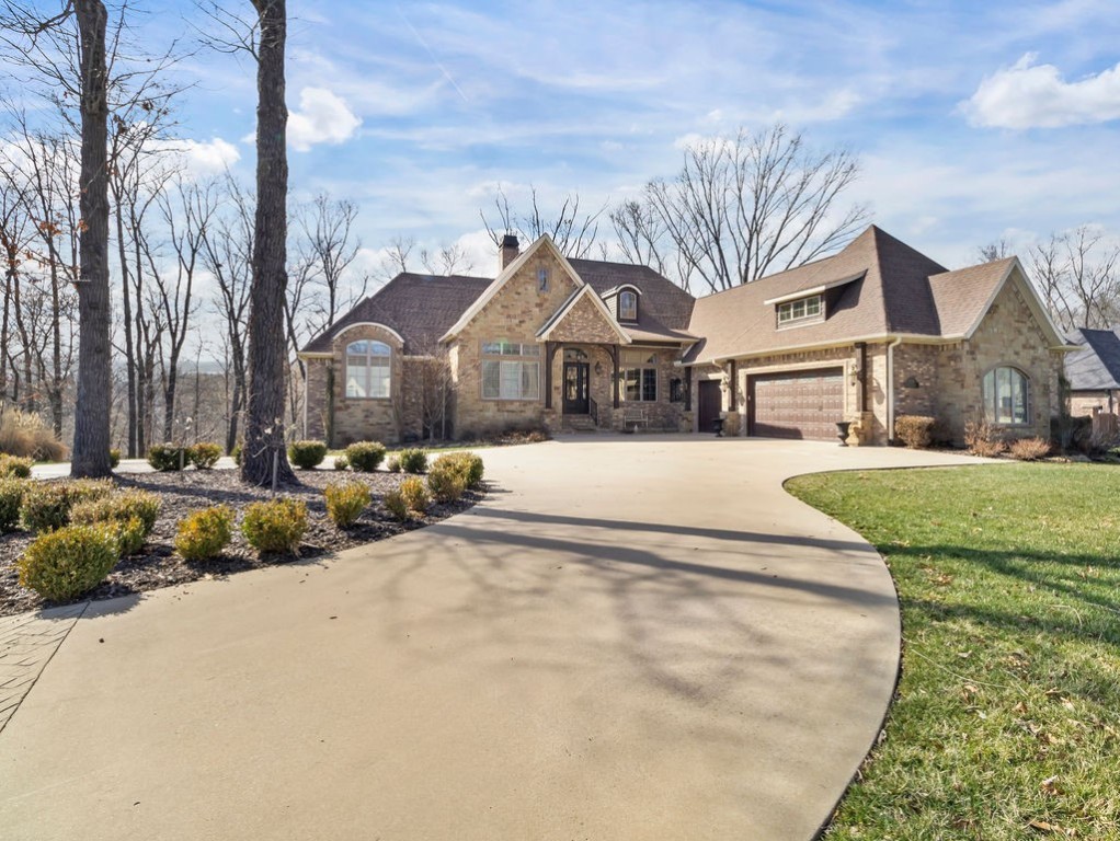 Gorgeous home on over two acres on a cul-de-sac in the prestigious Versailles community. Main level of home boasts a gourmet kitchen with two expansive quartz islands, breakfast nook, pantry, formal dining, office, half bath, mudroom and huge utility/laundry room. Soaring ceilings in the open living room and big windows provide an abundance of natural light and views onto the entertainer’s deck. Master suite with large walk in shower and a soaking tub. Walkout lower level features a second living room with wet bar along with four more bedrooms and three full baths. Enjoy the covered patio space and views of the large yard and surrounding woods. Wired/speakers in living, master, and outdoors. Navien tankless water heater. 10 zone sprinkler system. Three car garage and circle drive. All just four miles from Downtown Bentonville.
