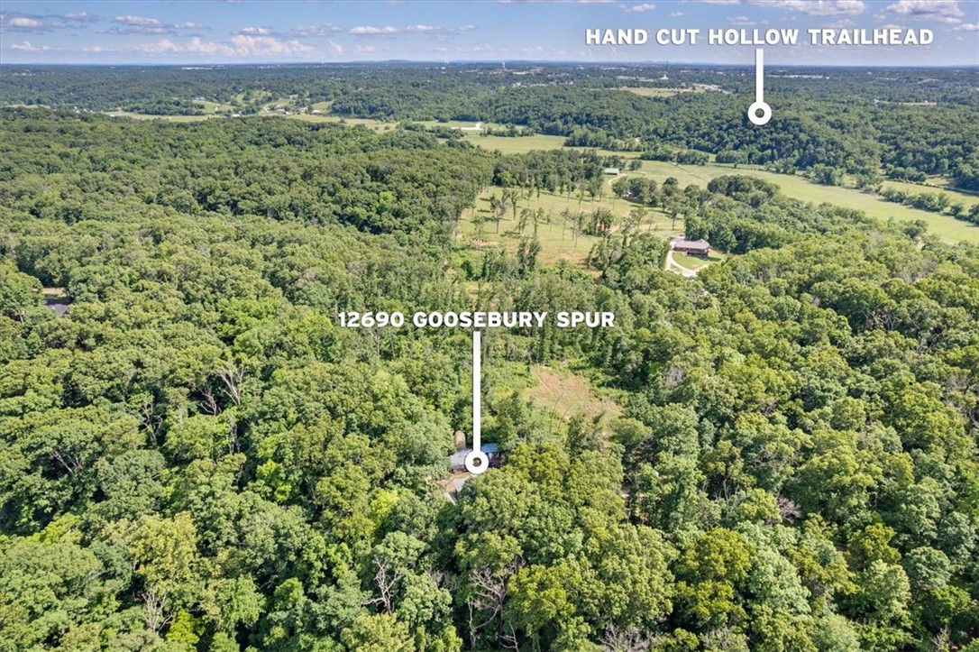 Location, location, location! Situated near bike trails, schools, Downtown Bentonville, and OZ trails, with scenic wooded surroundings, this private 6.35-acre property offers endless opportunities just minutes from downtown Bentonville. The home has a private well, a wood-burning stove, and a whole-house generator. Several outbuildings, including a well house with an outdoor shower and laundry room.  Perfect for building your dream home, starting an Airbnb, and more. Property is as is, and priced to sell.