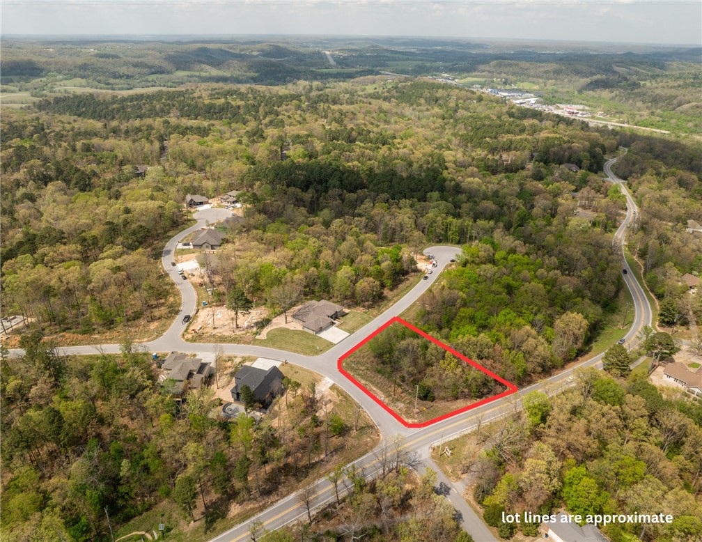 Gorgeous corner lot in the desirable Trail Ridge Subdivision, this beautiful 0.40-acre lot offers the perfect setting to build your dream home. Enjoy the privacy and minimal traffic that come with cul-de-sac living, along with the natural beauty that Bella Vista is known for. Located within the highly sought-after Bentonville School District, this property combines convenience with lifestyle. All public utilities are available, including high-speed internet.  Outdoor enthusiasts will love the easy access to nearby trails, perfect for walking, biking, and exploring the scenic surroundings. With a minimum build requirement of 1,950 square feet, this lot allows you to build your dream home.