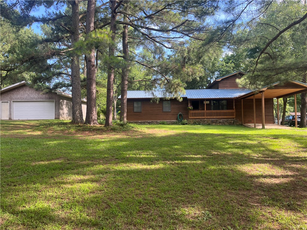 ****PRICE IMPROVEMENT***
Nestled on the end of the street in an established neighborhood, this charming 4 bed/2 bath house has something on everyone's wish list. Outside, sitting on 2.37 acres, is a large 24 X30 detached garage/shop which includes a wood burning stove and electricity, perfect for year-round hobbies or projects. Two additional out buildings (including a chicken coop) can be used for storage, gardening, or wherever your creativity may take you.  The flat, partly-wooded acres are serene, offering privacy and seclusion while being just a stone's throw away from the middle of town. Inside, there are two separate living areas, three bedrooms and a bath downstairs, while the primary suite upstairs is secluded and peaceful.  Enjoy small-town living and yet be conveniently located less than 30 minutes from Springdale, Fayetteville, and Eureka Springs. Make this well-built, well-loved, full-of-character property yours!
