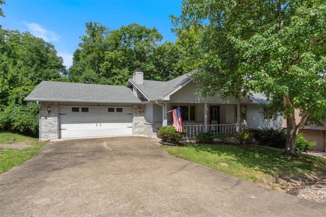Step onto a charming covered front porch and admire the stylish gray-toned brick, established shade trees, and native rock landscaping.  You’ll appreciate the generous driveway and oversized garage, complete with a windowed overhead door. Inside, the living room features a cathedral ceiling, a wood-burning fireplace, and a warm, inviting layout. The home also offers a great sunroom—your year-round spot to relax and enjoy beautiful Bella Vista views.  The eat-in kitchen is well appointed with abundant solid wood cabinetry and well-maintained casement windows—quality you won’t find in new homes.  SS appliance pkg is included.  From the home, head out to the wood deck and down to a bricked patio. Plus, there’s 244 sq. ft. of additional unfinished basement space—ideal for storage.  Location matters, and this one delivers: Lake Windsor Subdivision, tucked on a quiet cul-de-sac with access to Tanyard Creek and Little Sugar Trails. You’re also just minutes from Highway 71, shopping, clubhouses, golf—and the Oz Bike Park.