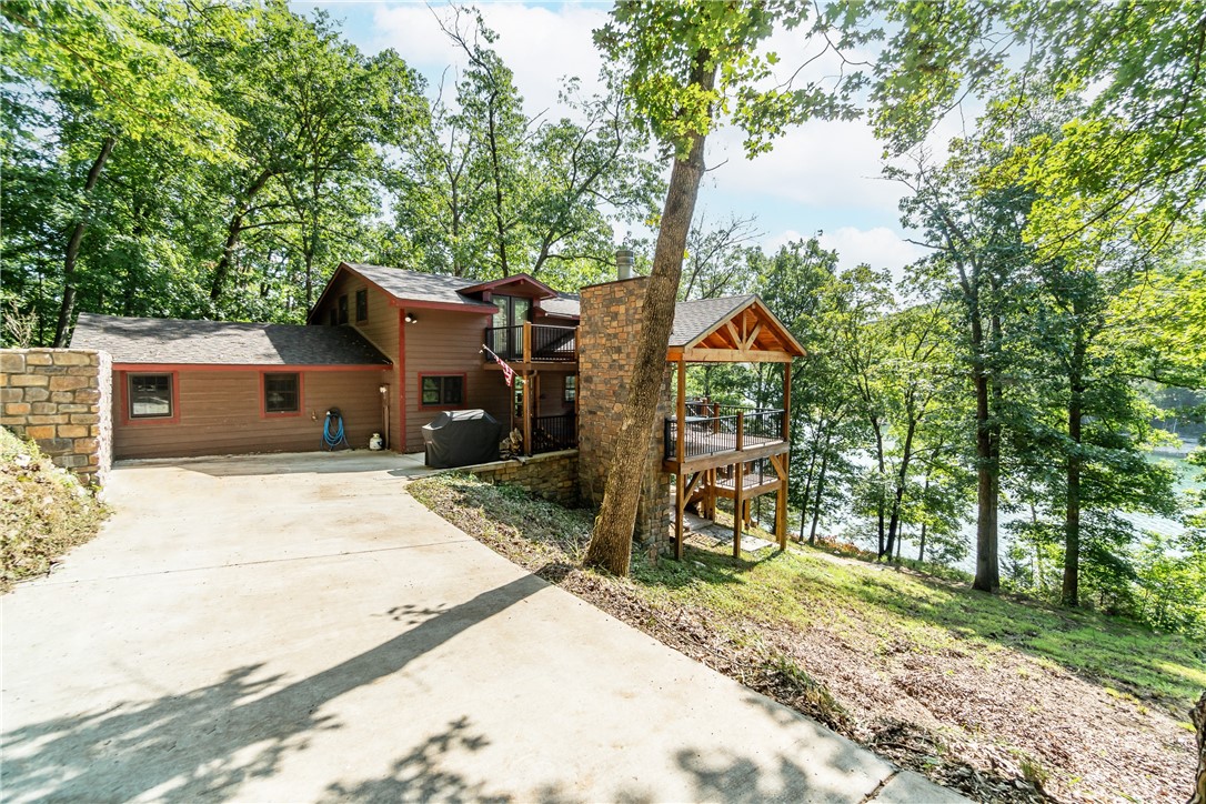Welcome to your own private lake front oasis with a 3 slip boat dock! This fully renovated home offers something for everyone, including two masters - one on the main level and a second in the loft - plus two more bedrooms downstairs with a 2nd living space that can be used as an additional bunk-room. Enjoy stunning cathedral ceilings with wood planking and floor-to-ceiling windows in the main living area, or lounge out on the expansive outdoor patio complete with an outside fireplace and plenty of sitting space. Plus, you'll have your own 3 slip private boat dock right at your fingertips! This home has been taken down to its studs for a full remodel, featuring all new roofing, windows, siding HVAC systems, water heaters and decks. Kitchen is equipped with a Bertazzoni gas rangeWith over one acre of land included, you'll have plenty of room to enjoy all that Beaver Lake has to offer. Don’t miss out on making this your very own lakefront retreat!