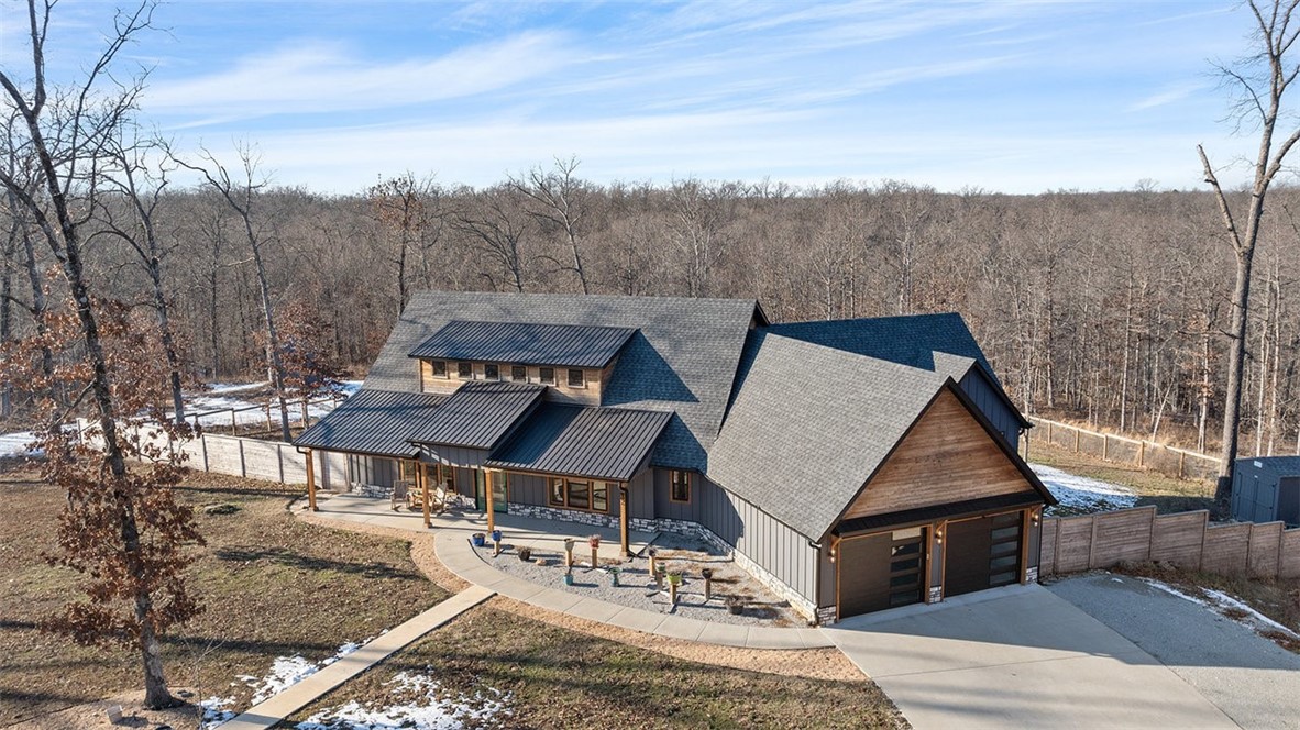 This stunning property offers the perfect blend of country living and modern convenience. Nestled on 7.75 acres yet only 5 minutes from Branchwood Recreation Center, Highlands Golf Course & Lake Loch Lomond. It’s located in a unique area of multi acre lots with underground utilities and offers ample space for a future RV garage, workshop or guest house. The thoughtfully designed one level split floor plan has two primary suites and a true chef’s kitchen featuring a Fisher Paykel dual range, high-powered range vent hood, and an extra wall oven. Two walk-in pantries provide ample storage space for all your culinary needs. Multiple decks & patio areas provide an ideal space for entertaining guests. This home is a rare find, combining luxury, privacy, and space in a peaceful Bella Vista setting all with quick and easy access to the new bypass. Two storage buildings total 288 sqft. Don't miss this opportunity to make it yours!