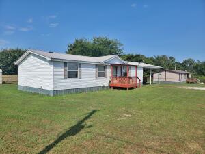 Clean doublewide just off pavement. Divided floor plan. Large half acre yard no restrictions. Metal roof.. Two bay carport. Mobile home will be transferred with a bill of sale.