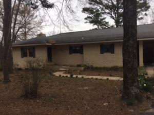 A lovely, quiet country setting is the location of this spacious home on 1.52 acres--rural yet close to town.  Four bedroom, 3 bath home includes a mother-in-law quarters with separate entrance. Large deck off sunroom overlooks the large fenced backyard.  Bonus basement/saferoom off carport is not included in square footage. Also has a detached storage building.