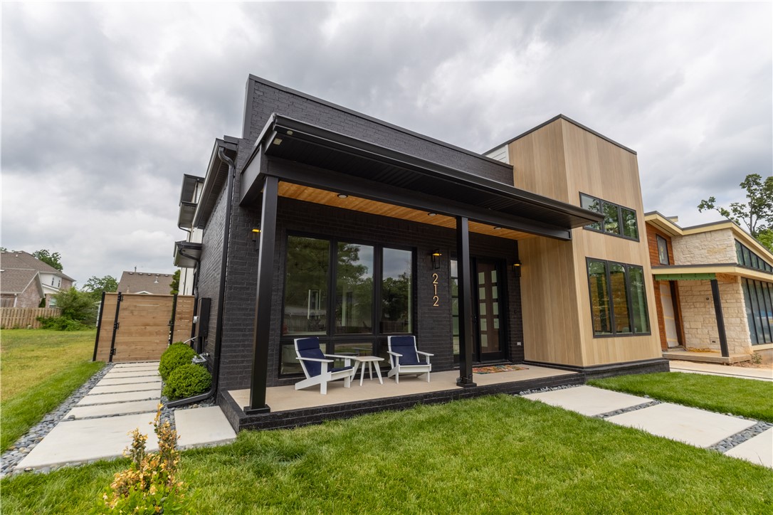 Welcome to an exceptional custom new build in the heart of Downtown Bentonville! Step inside to an expansive open-concept living area featuring white oak built-ins, exposed beams, and white oak flooring throughout the entire home. The chef’s kitchen includes white oak cabinetry, Taj Mahal quartz countertops and full-height backsplash, a 48" high-end Dacor gas range, and butler's pantry. Work comfortably from home in the impressive private office boasting 18-foot beamed ceilings and oversized windows. The home features a first-floor primary bedroom, three private ensuites upstairs, and powder rooms on both levels. Third-floor bonus space offers flexibility for a second office, media room, or fitness area. Additional features include large laundry rooms on both floors, a dedicated dog wash, and outdoor living with room for a pool (rendering in images). This home delivers luxury living just steps from trails, restaurants, and all the energy of Downtown Bentonville. Don’t miss your chance to be part of the excitement!