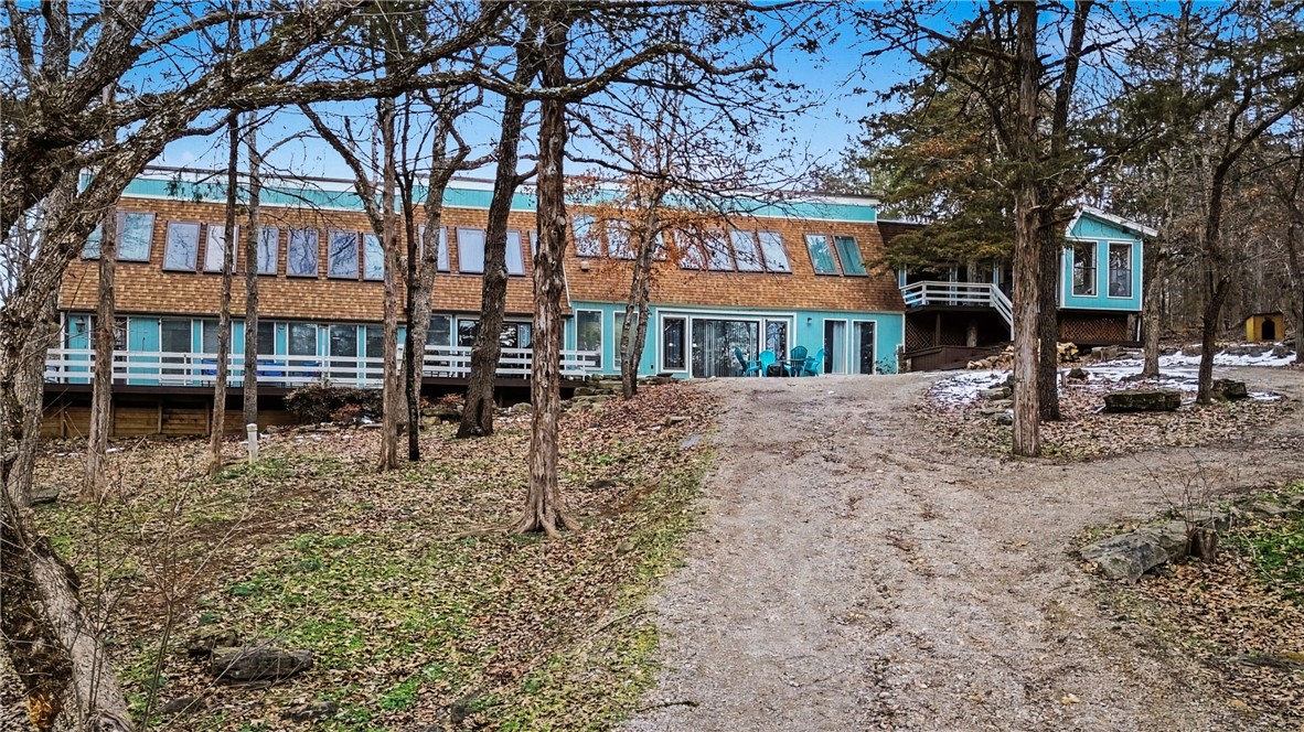 Absolutely one-of-a-kind, fantastically renovated retreat on 13 acres including 900+ feet(!) of Kings River FRONTAGE! Spacious 6,100 sq ft home with wraparound deck offers 5 bedrooms & 4.5 baths, with 20+ angled skylights that bathe the rooms in natural light. Large kitchen features expansive prep space for cooking & stainless appliances. Ideal for entertaining with fire pit, game room, & exercise room with indoor hot tub. Recent updates include new roof within past 3 years & new heat pumps. Large, oversized detached garage building provides excellent storage for vehicles, boats, or toys. Riverfront acreage allows for several small cabins to be built. Enjoy fishing, floating, & peaceful river views right outside your door. Currently used as successful 5-star vacation rental, property offers versatility as primary residence, second home, or investment opportunity. Rare chance to own an exceptional riverfront property in a truly scenic setting. Minutes to Branson, Big Cedar, & Eureka Springs. Must see!