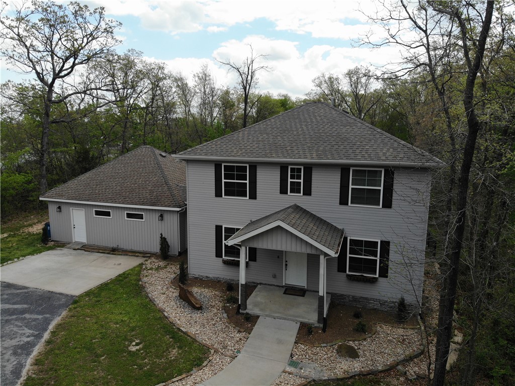 Spacious, Secluded Living in the Heart of Gravette! Beautiful 2-story home is offering 2,601 sq ft, 4 bedrooms, and 2.5 baths. Tucked away on 1 private acre, this property offers the perfect blend of peaceful seclusion and convenient in-town living. This home features vaulted ceilings, a huge living room perfect for entertaining or a home theater, and a main-floor master suite with walk-in closets. The eat-in kitchen includes a large island and walk-in pantry, providing plenty of space for cooking and gathering. Enjoy both a formal entry and convenient mudroom entrance. Step outside to a large back deck overlooking the huge fenced backyard, ideal for entertaining. The professionally landscaped front yard adds great curb appeal. Located just minutes from parks, schools, and walking trails in Gravette, Arkansas, this home offers the rare combination of privacy, space, and convenience.