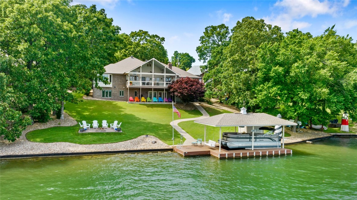 OPEN HOUSE CANCELLED- UNDER CONTRACT! Located on the widest portion of Loch Lomond, this home is just steps away from the water & an easy walk to your own private boat dock with a lift. Summer fun activities like water skiing, fishing, kayaking, watching fireworks over the water & more await. When you walk in, you will greeted by panoramic lake views. On the main level, you will find a dedicated office, living area with a fireplace, access to a covered deck, kitchen with an induction stove, dining/sitting room, primary bedroom suite with a large walk-in closet, guest bedroom, full bath & a half bath.  The basement has a second living room with a kitchenette that could easily be made into an in-law suite or short term rental. A guest bedroom, full bath & an additional room with exterior access for workshop/storage can also be found on the basement level. The 2-car garage is oversized. New roof (2017 ) & new HVAC/furnaces x 2 (2020 & 2021). Remodeled with new paint, flooring, fixtures, appliances and more!