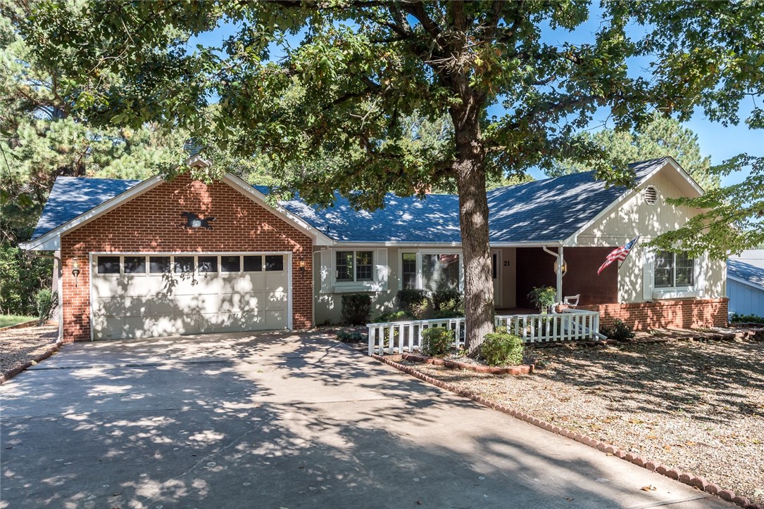 Charming home in Bella Vista! New landscaping provides curb appeal.This home sits in a great, central location with easy access to golf courses, parks, trails, and I-49. Quality features throughout including solid windows across back of home floor to ceiling, new floors, and new paint. Spacious layout is great for hosting. Eat-in kitchen has island with counter bar seating, and abundant storage space. Huge living room has floor to ceiling brick fireplace, wood beams, and vaulted ceiling. Living room has access to the sunroom, a great additional living space complete gorgeous views and views of golf course in winter. Master bedroom has attached bath. Large deck provides outdoor living space. Separate deck in woods. Short distance to Sugar Creek for swimming.Workshop area in walk-out basement. Enjoy amazing community amenities such as golf courses, mountain bike trails, lakes, parks, and much more!