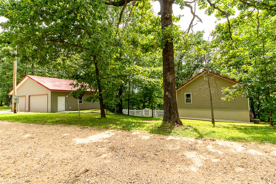 Situated on 3.16 wooded acres near Beaver Lake, this property offers privacy, room to spread out, and a hard-to-find 37' x 30' detached shop with approximately 1,110 square feet. Whether you operate a home business, need space for equipment, boats, vehicles, woodworking, or hobbies, this shop provides the flexibility you've been looking for. The home offers a functional layout and low-maintenance living, allowing you to spend less time on upkeep and more time enjoying the property. Surrounded by mature trees and abundant wildlife, there's plenty of room to create walking trails, relax outdoors, or take advantage of nearby lake access for boating, fishing, and kayaking. If you're looking for acreage, privacy, and a large shop near Beaver Lake, come and check this place out! Call for your private showing.