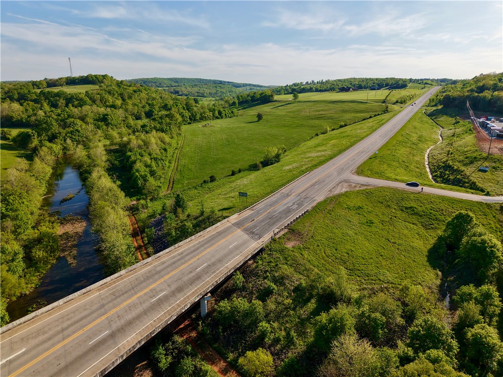 Prime 25.5± acre opportunity in Huntsville, AR with highway frontage on Hwy 412 and excellent visibility. Zoned DUZ (Dual Use Zone) allowing C-2 or R-1, offering flexibility for commercial development, investment, or a future homesite. Convenient access near Hwy 23 with city water, sewer, electric, and fiber available. Holman Creek runs along the eastern edge, adding character and natural beauty. Located in a rapidly growing area with strong daily traffic counts.