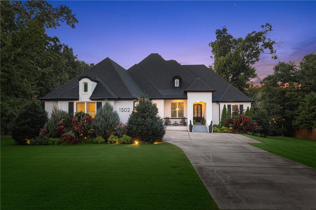 Stunning Versailles home on 1.94 private acres in a quiet cul-de-sac with wooded views and private pool. Open floor plan with wood floors, 10' ceilings, vaulted beamed living room, stone fireplace, built-ins, and formal dining. Kitchen features oversized quartz island, gas range with stacked stone surround, walk-in pantry, built-in bar, and breakfast nook. Primary suite offers soaking tub, large glass shower, walk-in closet connected to laundry. Mudroom with built-ins off garage. Main level includes 3 guest bedrooms and 2 full baths. Upstairs bonus room with built-ins, walk-in closet, and full bath can serve as a 5th bedroom. Screened porch overlooks the private backyard, with covered patio and beautiful pool below. Just 10 minutes to Downtown Bentonville with quick access to schools, Coler Mountain Bike Preserve, and all Northwest Arkansas amenities. Welcome Home!