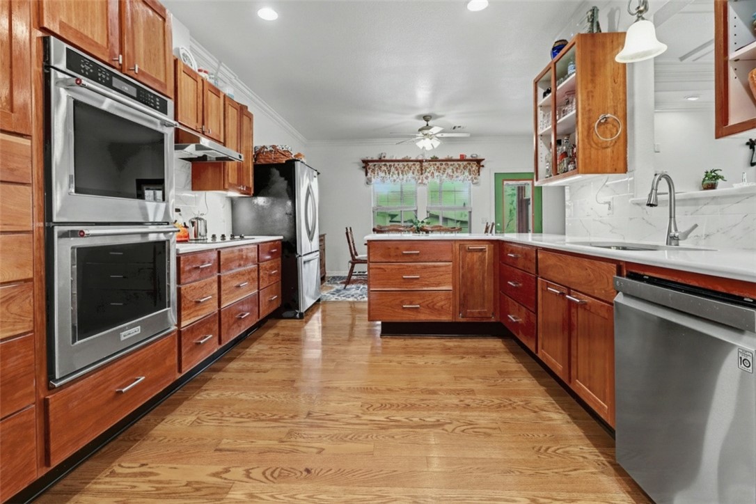 Beautifully updated 3-bedroom home plus office featuring a spacious living room with remote-controlled Kozy Heat fireplace. The kitchen was remodeled in 2024 with cherry cabinetry, quartz countertops, double ovens, and a functional layout ideal for cooking and entertaining. Cabinet doors for the open shelving are available, but the owner preferred the open look. A water hookup is located in the drawer stack left of the stove if you prefer relocating the refrigerator. The primary suite offers an updated bath with a new walk-in shower. Additional updates include new LVP flooring, 2021 roof with 30-year shingles, new garage door and opener in 2022, and new heat pump in 2025. Enjoy the screened porch. Nice flat corner lot. Refrigerator, washer, and dryer convey. Flexible living spaces, quality updates, and thoughtful details throughout make this home move-in ready.