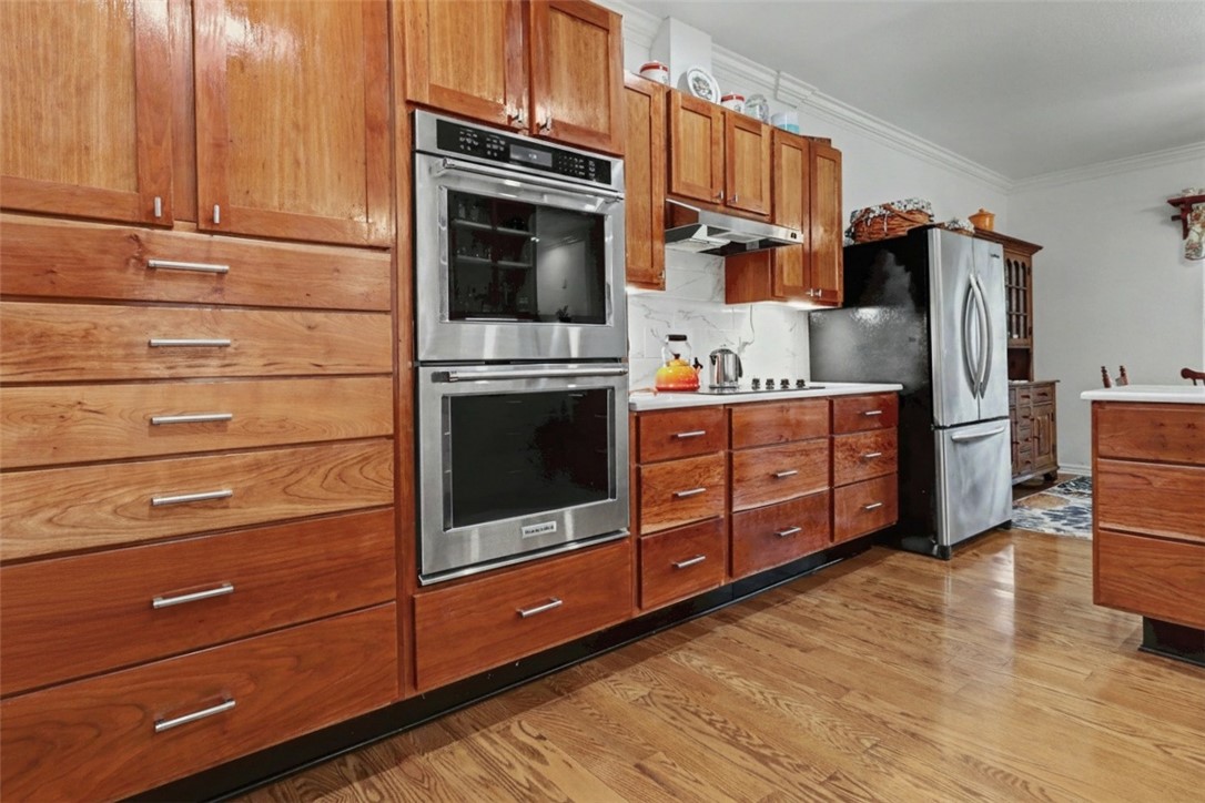 Beautifully updated 3-bedroom home plus office featuring a spacious living room with remote-controlled Kozy Heat fireplace. The kitchen was remodeled in 2024 with cherry cabinetry, quartz countertops, double ovens, and a functional layout ideal for cooking and entertaining. Cabinet doors for the open shelving are available, but the owner preferred the open look. A water hookup is located in the drawer stack left of the stove if you prefer relocating the refrigerator. The primary suite offers an updated bath with a new walk-in shower. Additional updates include new LVP flooring, 2021 roof with 30-year shingles, new garage door and opener in 2022, and new heat pump in 2025. Enjoy the screened porch. Nice flat corner lot. Refrigerator, washer, and dryer convey. Flexible living spaces, quality updates, and thoughtful details throughout make this home move-in ready.