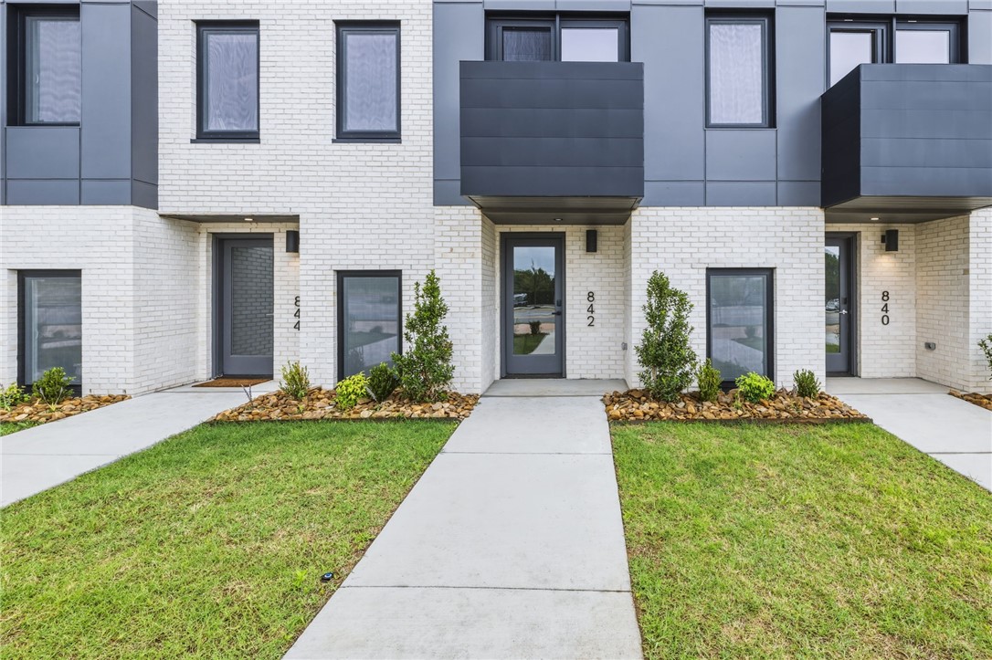 Enjoy the best of downtown Bentonville living in this luxury Lightbox townhome—designed for ones who want walkability, style, and smart design. Located just one block from the new Walmart Home Office campus and directly across from 8th Street Market, this North Light residence offers expansive northern views, including the Momentary. The architecturally striking design allows natural light to pour in from third-floor clerestory windows down through the open stairwell to the main living level, creating a bright, calm, and modern feel throughout. The kitchen blends form and function with a European Bosch appliance package, induction range, white oak cabinetry, and bold quartz countertops. Across the catwalk, the living area is framed by oversized windows—perfect for relaxing or entertaining with a view. Upstairs, two private bedroom suites each feature their own bath, offering flexibility for guests, work-from-home space, or a refined second-home lifestyle—all just steps from Bentonville’s dining, arts, and trails.