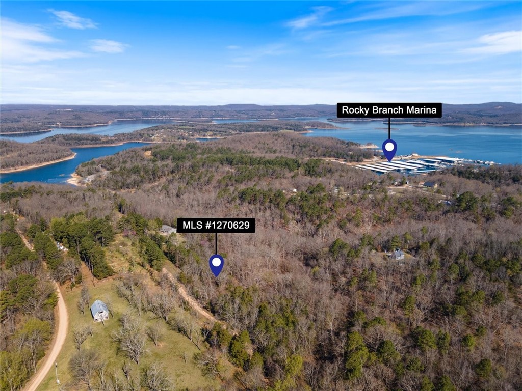 Discover the epitome of tranquility! Embrace nature's embrace on 3.8 acres of picturesque, sloped, and wooded terrain. Situated near the esteemed Rocky Branch Marina & Campground on stunning Beaver Lake, this haven offers unparalleled access to hiking & biking trails and the renowned Hobbs State Park. Nestled outside city limits, yet a mere 15-minute drive from the vibrant pulse of Downtown Rogers, seize the opportunity to craft your dream lakeside retreat or cabin in this serene locale. Don't let this chance slip away to create your own slice of paradise!