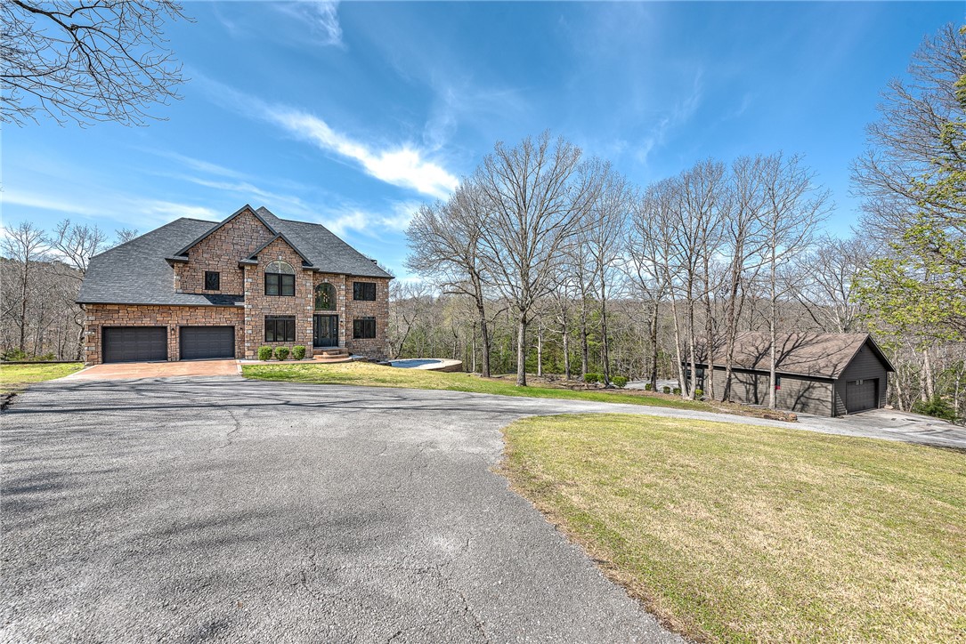 With its modern amenities, expansive outdoor spaces and unbeatable location, this "Stone Haven" at 8361 Forest Hills Lane is more than just a property; it’s a lifestyle. Fully renovated in 2021 and meticulously maintained, this turnkey home is situated in a gated estate community - offering privacy and peacefulness. This stunning home features an open-concept design with matte black fixtures, porcelain tile, Carrara marble, arched windows, and smart home technology for modern convenience. A versatile lower level provides direct access to the pool and includes a wine cellar, as well as multiple flex spaces - perfect for home gym, office or more. Outside, enjoy the peace and relaxation of a covered patio and inground pool with a new retaining wall for expanded sun deck. The detached, drive-through garage for boats, cars, or bikes provides the perfect storage space for hobby enthusiasts. This exceptional home sits just 1 mile from the HWY 12 boat ramp, 3 miles to Prairie Creek Marina and 5 miles to Downtown Rogers.