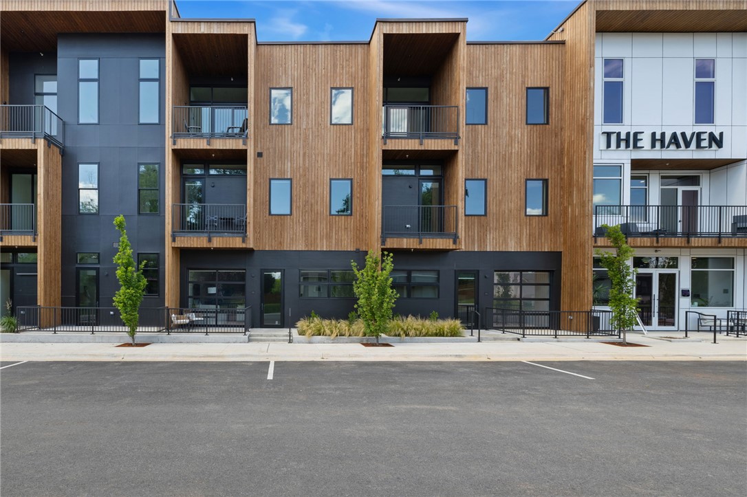 Luxury condo living in the heart of downtown Bentonville at The Haven, a boutique 29-residence community ideally positioned between the Bentonville Square and the new Walmart Home Office campus. This ground-level one-bedroom condo with flex space offers a blend of modern design, functionality, and investment potential, including eligibility for short-term rental use. Thoughtfully designed interiors feature white oak cabinetry with walnut stain, quartz countertops, premium Bosch appliances, solid 8' doors, and expansive windows that fill the space with natural light. A distinctive glass-paneled overhead door opens to a private patio, creating seamless indoor-outdoor living. The bedroom accommodates a king-size bed and includes a walk-in closet with custom built-ins. Additional highlights: a dedicated pantry, oversized laundry room, reserved off-street parking, and interior storage room ideal for bikes or owner storage. Enjoy lock-and-leave convenience near trails, dining, shopping, art, and entertainment.