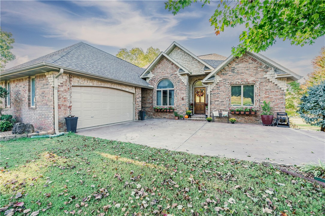 Brick and stone home overlooking the Executive Golf Course with pond and butterfly garden views. Built with attention to detail and quality craftsmanship throughout. The kitchen features custom cabinetry, granite countertops, pull out drawers, pantry, built in double ovens, built in microwave and a new refrigerator. Main level split floor plan includes a spacious primary suite with walk in shower, his and her closets, double vanity and soaking tub. Two additional bedrooms share a Jack and Jill bath. Composite deck with hot tub overlooks the golf course and pond. Main level double garage plus two additional heated garages on the lower level, one with a closet that was previously a bedroom and can be converted back if desired. Lower level also includes a large wet bar and screened porch. Located near golf and community amenities.