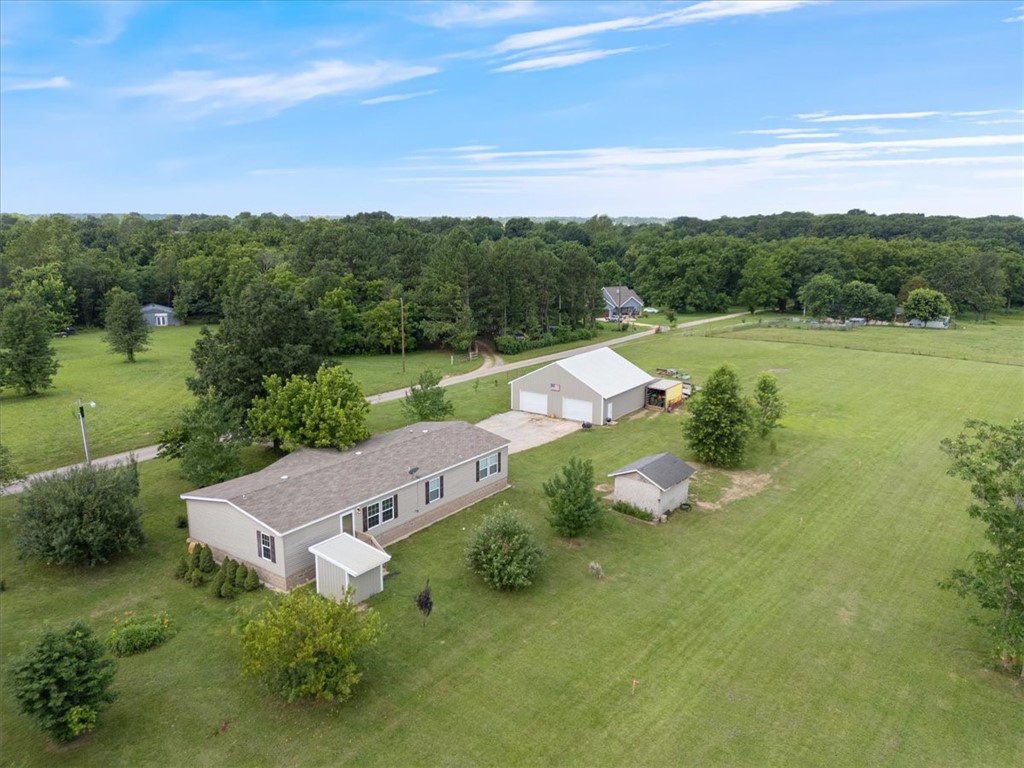 Located near Bentonville West this home offers country living on the edge of the city. Move-in ready and well taken care of. Trees galore including Apple, Plum, Peach and Pear as well as Maple and Red Buds. This is a well-kept Clayton Modular Home. In addition, a large 40X40 garage and workshop with 10X40 attic storage. The property has natural gas, electric and public water available at road frontage. There is currently a 500' well with new 2 HP pump that supplies plenty of water for the residence and property.