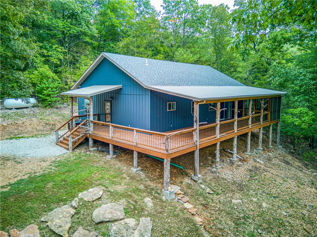 Weekend Getaway, this stunning newly constructed property offers a blend of modern amenities and natural beauty. With its energy-efficient design and furnished interior, it's ready for immediate enjoyment. The spacious 1500 sq. ft. floor plan boasts live edge molding, 10-foot ceilings, vinyl plank flooring, Kabinart cabinets, and granite countertops. You'll appreciate the quality craftsmanship with solid knotty alder wood interior doors and 2x6 exterior walls for added durability. The outdoor space is equally inviting, featuring a generous 50x12 covered deck, a screened-in room on the porch, and the year-round spring-fed creek on the property. The property's location is exceptional, just minutes from Buffalo National River and close to Bass Pro's new development at Marble Falls. This property comes with all contents including kitchenware and linens, ready to use as your weekend retreat or nightly rental.