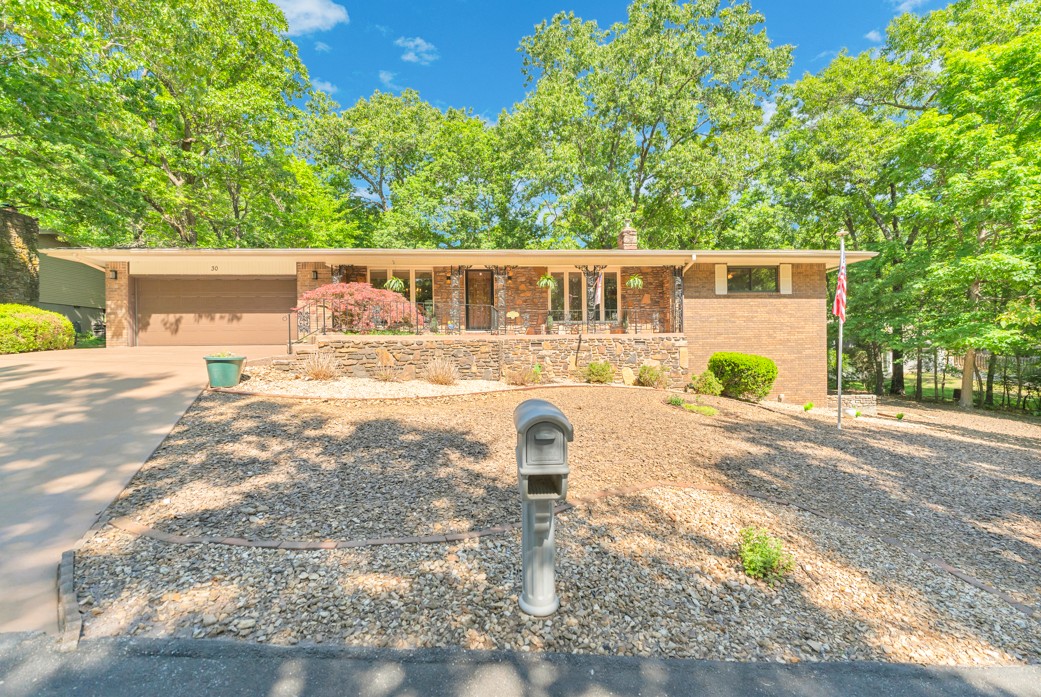 This home can easily be described in two words – a classic! The first thing you notice is the front porch, which is begging you to pull up your rocker and enjoy your favorite beverage. Inside, the hard-wood floors, the natural wood trim and kitchen cabinets, and the large light-emitting windows will quickly grab your attention. This home has plenty of room to enjoy, whether it's on the enclosed back patio or the 500+SF, heated and cooled, unfinished basement, just waiting for you to decide what it should be. The HVAC system is 1-year old in July; the roof was replaced 3 years ago, and the wood-burning stove in the living room is just two-seasons old. Enjoy your visit; take your time, and become acquainted with this “classic” beauty!  Walking distance to Bella Vista Recreation Center, Tennis Center, and Kingsdale Pool.  Easy Access to I49 for daily commute.  This home is calling you home.
