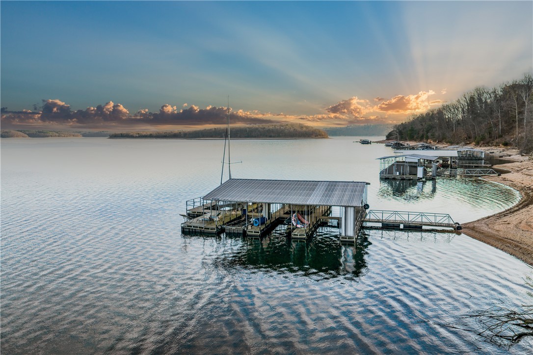 Discover the perfect place to build your dream lake retreat on Beaver Lake! This beautifully wooded 0.62-acre lot in the desirable Serenity Point subdivision is ready for your vision — and it's already perced for a 4-bedroom home. Two deeded boat slips in a community dock make lake days completely effortless, ideally situated between the Hwy 12 bridge and Prairie Creek Marina on the west side of the lake. Utilities are in place with public water on-site, underground electric, and natural gas available. The gently rolling, partially wooded topography offers stunning building opportunities with privacy and natural beauty. Located just minutes from Downtown Rogers, this is one of the last available lake lots this close to the heart of NW Arkansas — combining true Beaver Lake living with unbeatable convenience. Opportunities like this simply don't come along often. Don't miss your chance to make it yours!