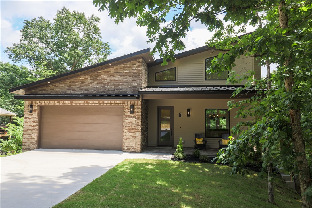 Modern luxury meets the serenity of nature in this stunning new construction custom home tucked among the trees of Bella Vista. This thoughtfully designed 3-level home offers soaring windows and a true “treehouse” feel, bringing the outdoors in with natural light and wooded views from every level. Contemporary finishes shine throughout with gorgeous quartz countertops, recessed lighting inside and out, custom wall paper and cabinetry, custom metal railings inside and out, composite decking, tankless water heater, and durable Hardie plank siding for low-maintenance living. The striking modern architecture is perfectly paired with warm natural textures and clean lines. Overlooking the Sugar Bridge Trail and less than 5 minutes from the new bike park, this home offers immediate access to Bella Vista’s renowned biking and walking trails while still feeling private and peaceful. A rare blend of modern design, quality construction, and outdoor lifestyle living.