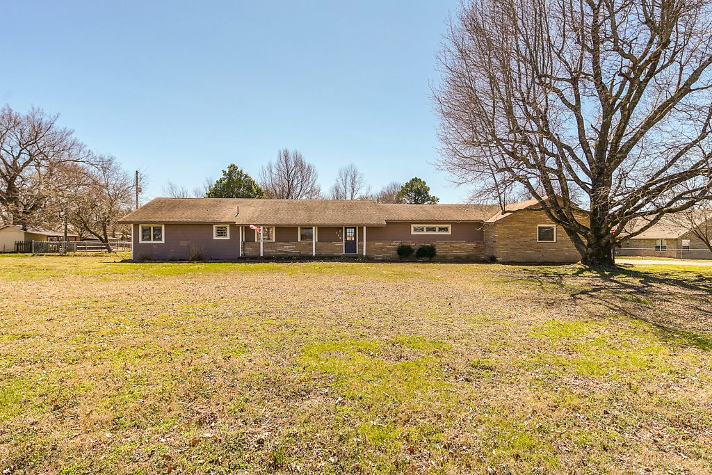 Historic Downtown Prairie Grove originally built in 1958 on 1 acre! Fully fenced, with covered wood stone hearth on back patio, separate storage building, and gorgeous oak tree! Updated kitchen with farmers sink and butcher block. Remodeled master bath including walk-in closet, soaking tub/shower combo. House is spread out down a long hallway. Workshop inside garage. Original wood floors throughout. Real cedar wood walls in living room. Nest thermostat, tankless water heater, cat5 network cabling.