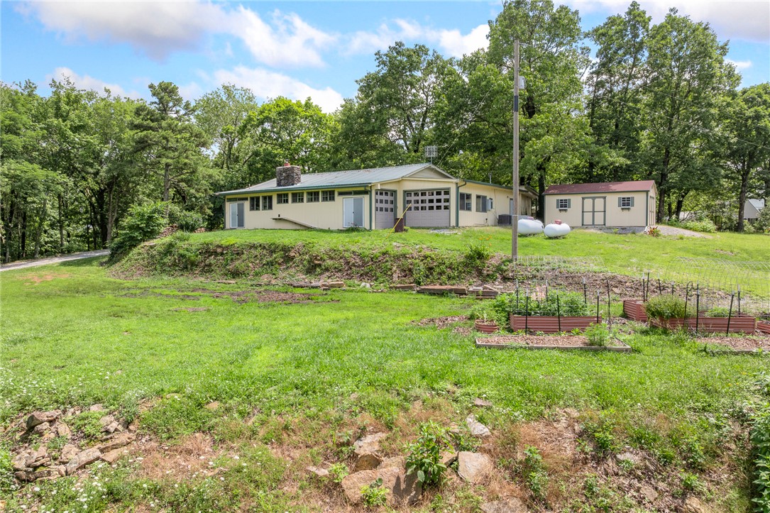 Located just south of Jasper, this 3 or possibly 4 bedroom 2-bath home sits on 5 gorgeous scenic acres with beautiful views. The property offers a unique opportunity with a separate living area featuring its own private entrance, previously used as an Airbnb rental, making it ideal for guests, supplemental income, or a home office. The home includes all appliances, a wood-burning stove, and a whole-house generator for added convenience and peace of mind. Multiple garages provide ample space for vehicles, ATVs, equipment, hobbies, or workshop use, while additional storage shed offer even more room for tools and outdoor gear. Enjoy the outdoors with 2 ponds, raised garden beds, fruit trees and plenty of usable land. Property also features a concrete slab for an additional shop or a place to park your RV. Whether you're looking for a full-time residence, vacation property, or home with income potential, this versatile Jasper property offers a desirable location, great views, and room to enjoy the Ozarks lifestyle.