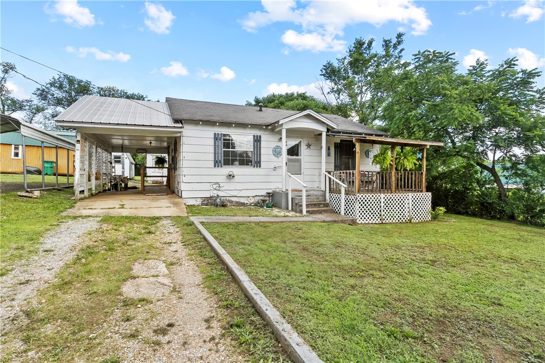 Welcome to this well-kept home in the heart of Yellville, Arkansas! It is nestled on FIVE city lots, this cozy cottage offers the perfect blend of simplicity, comfort, and outdoor space. While the home is easy to maintain, the expansive yard provides endless possibilities for gardening, entertaining, pets, play, or future projects! Inside you will find a comfortable living area and an inviting atmosphere! You instantly feel right at home! Outside you have 2 outbuildings, a covered carport, a back porch, and a covered front porch! Whether you are looking to downsize, purchase your first home, invest in a rental, or enjoy a slower pace of life, this property offers room to spread out without sacrificing the convenience of being right in town! Enjoy the rare opportunity to own a cozy home with the space and flexibility that 5 lots provide- all within the city limits of Yellville, Arkansas!