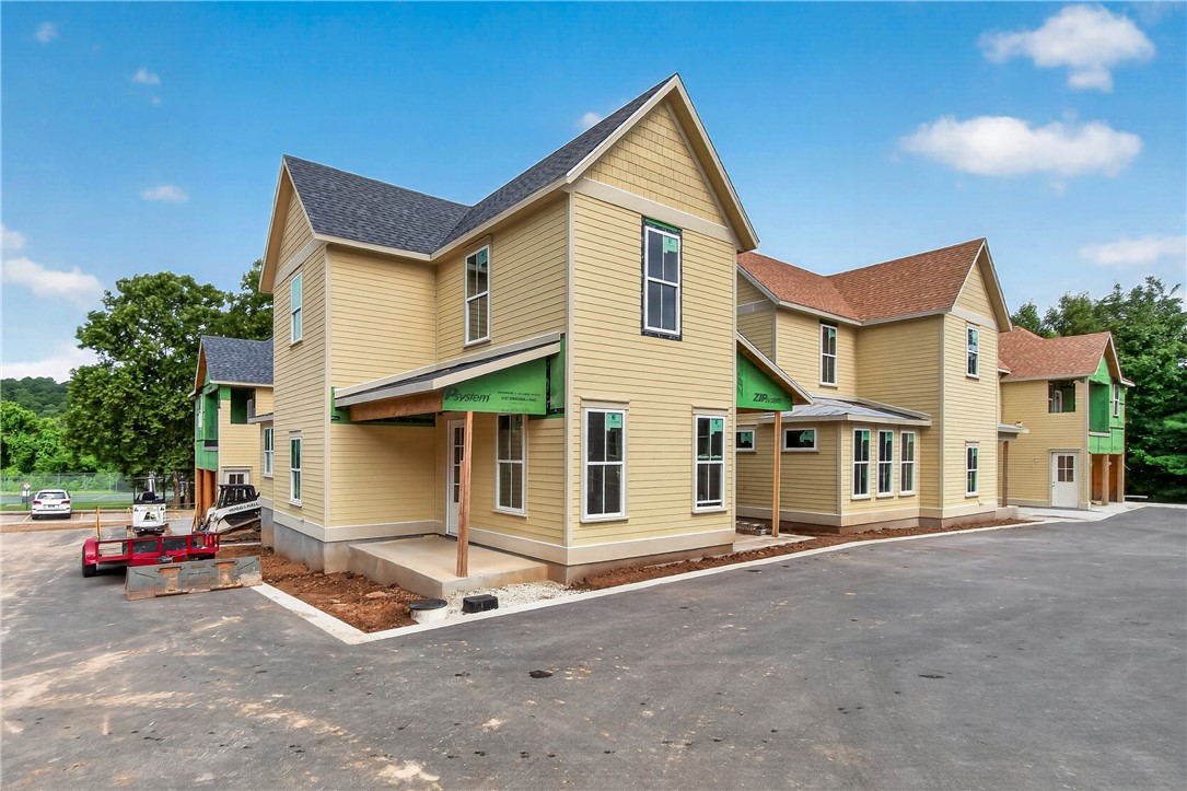Welcome to Smyth Crossing – where history, community, and thoughtful design meet in East Fayetteville’s coveted Crossover area. Born from a vision to preserve the cherished home of immigrant Peter Smyth, this neighborhood blends heritage with modern living. Tree-lined streets, green spaces, and timeless architecture create a place to connect and celebrate the Ozarks’ beauty. Among its standout homes, The Prow House combines charm, function, and versatility. It features 4 beds, 2.5 baths in the main home- plus 1-bed, 1-bath apartment above the garage, perfect for guests or extended family. A welcoming front porch and private courtyard offer inviting spots for morning coffee or evening tea, while the open floor plan inside flows effortlessly for entertaining and everyday living. Luxury finishes and an efficient layout make this home as stylish as it is comfortable. Minutes from top schools, parks, trails, and shopping. More than a neighborhood, it’s a living tribute where legacies are honored and new stories begin.