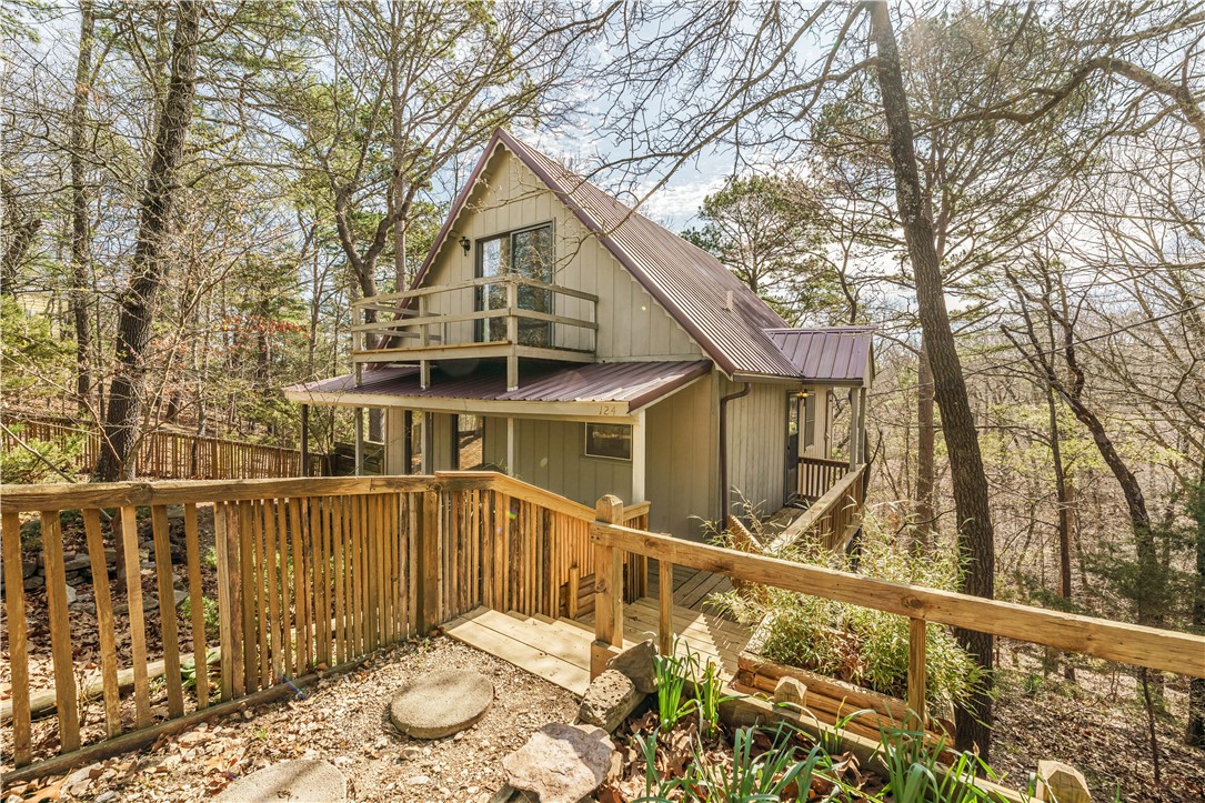 This cozy, adorable cottage is within walking distance to downtown.  Open floor-plan downstairs, with two spacious bedrooms upstairs.  The front bedroom has a balcony big enough for a cafe table and chairs to enjoy morning coffee, overlooking the fenced-in garden space.  Clean and neat as can be!  The back deck overlooks the forested woods, where you will see deer, fox, rabbits and other wildlife.  With a metal roof and conveying washer and dryer, this home is in great condition and ready to go.  This could be a wonderful starter home, an investment property for long-term rental, or your own private getaway.  Call to see it today!